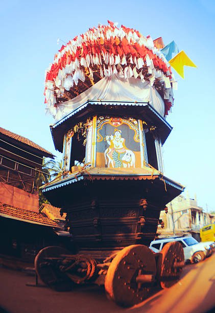 Traditional holly chariot with wooden wheels, flags and paintings of hindu gods.Preparation for festival. India, Gokarna.